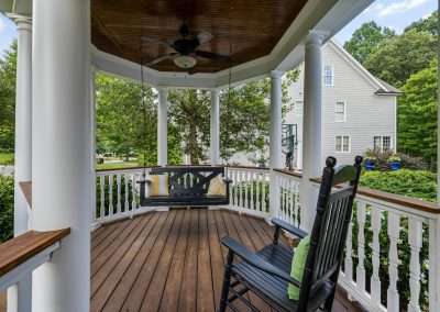 Porch with black swing and rocking chair, showcasing quality craftsmanship and inviting outdoor space, relevant to Charleston Paint Contractors' exterior painting services.