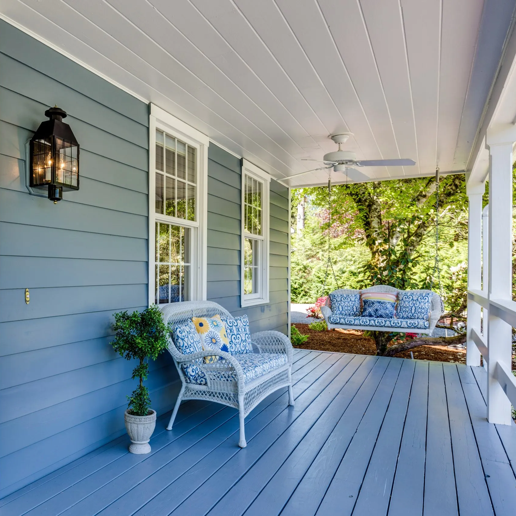 A photo of an outdoor space with a chair and porch swing